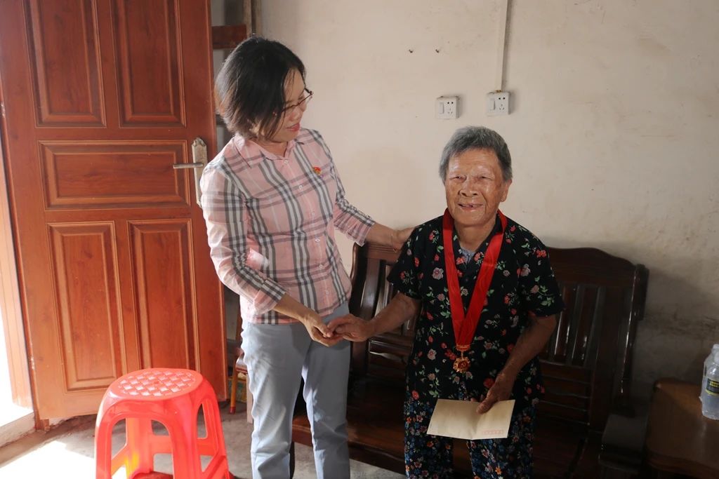 市人大常委会主任邓玉妹为党龄满50年党员林婉蓉佩戴"光荣在党50年